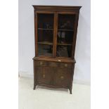 AN AMERICAN CHERRYWOOD DISPLAY CABINET the outset moulded cornice above a pair of glazed doors with