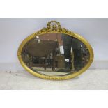 A CONTINENTAL GILT FRAME MIRROR the oval bevelled glass plate within a reeded frame with ribbon