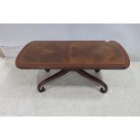 A MAHOGANY CROSS BANDED COFFEE TABLE of rectangular outline with scroll legs 41cm (h) x 112cm (w) x