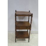 A 19TH CENTURY MAHOGANY THREE TIER WHAT NOT with frieze drawer and baluster uprights on castors