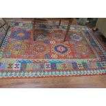 AN ORIENTAL WOOL RUG the multicoloured ground with serrated panels palmets and hooks 207cm x 297cm