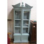 A CONTINENTAL BLUE PAINTED DISPLAY CABINET the architectural pediment above a pair of glazed doors