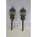 A PAIR OF BRASS WALL MOUNTED LANTERNS each of octagonal form with glazed panels hung with laurel