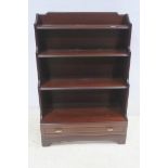 A MAHOGANY FOUR TIER OPEN FRONT BOOKCASE with drawer to base on shaped platform 123cm (h) x 83cm