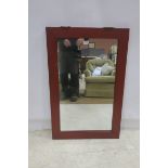 AN ORIENTAL RED LACQUERED MIRROR the rectangular plate within a moulded frame with brass hangers