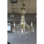 A CONTINENTAL GILT BRASS AND CUT GLASS FOUR BRANCH CHANDELIER hung with faceted chains and pendent