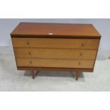 A CIRCA 1960s TEAK CHEST of three long drawers on cylindrical tapering legs 71cm (h) x 105cm (w) x