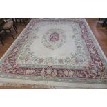 A CHINESE WOOL RUG the white ground with central floral panel within a conforming border 366cm x