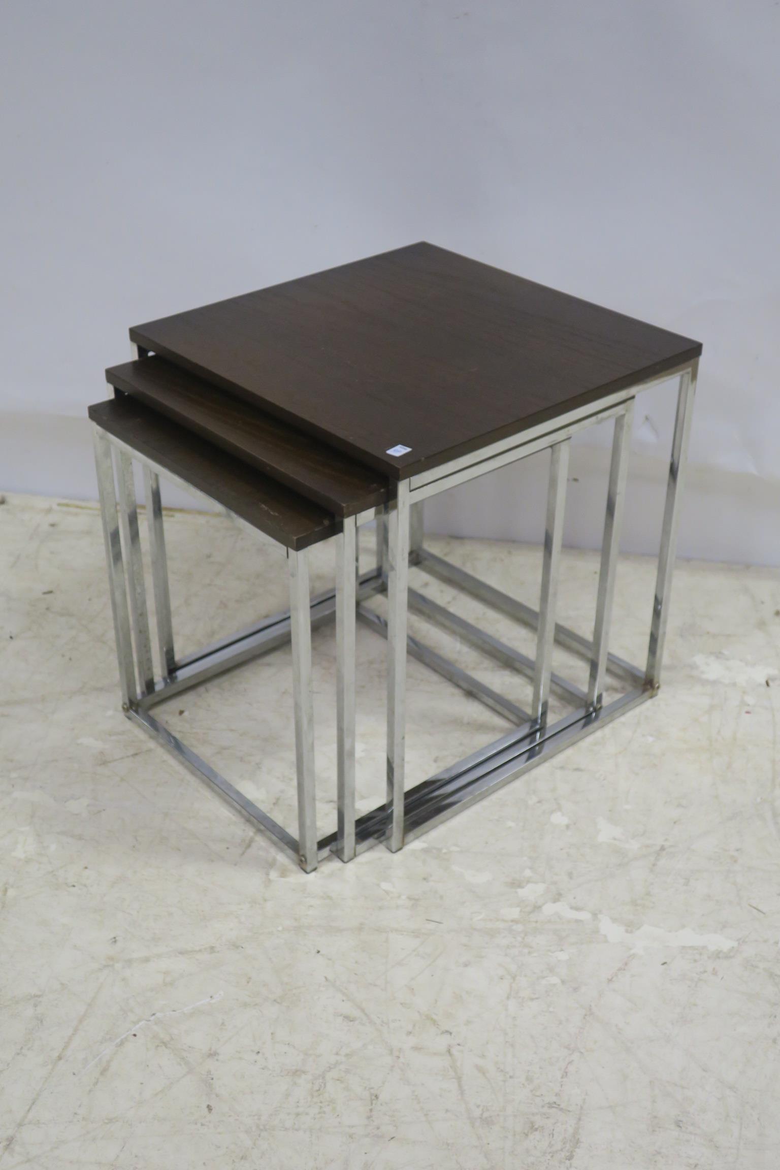 A NEST OF THREE TEAK AND CHROME TABLES CIRCA 1960 each of rectangular outline on square moulded