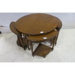 A WALNUT CROSS BANDED COFFEE TABLE of circular outline containing three demi lune tables raised on