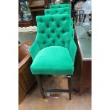 THREE GREEN PLUSH VELVET UPHOLSTERED BAR STOOLS each with buttoned backs on ebonised legs