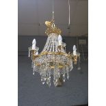 A CONTINENTAL GILT BRASS AND CUT GLASS SIX BRANCH ELEVEN LIGHT CHANDELIER hung with faceted chains