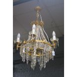 A CONTINENTAL GILT BRASS AND CUT GLASS SIX BRANCH ELEVEN LIGHT CHANDELIER hung with faceted