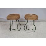 A SET OF TEN HARDWOOD LOW STOOLS with saddle seat on metal bases