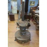 A CONTINENTAL CAST IRON FREE STANDING STOVE the shaped top with lidded compartments and brass