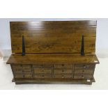 A STAINED WOOD TRUNK of rectangular outline the hinged lid with twelve short frieze drawers on