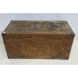 AN ORIENTAL CAMPERWOOD BRASS BOUND TRUNK the carved overall with figures and landscape the