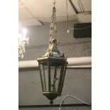 A BRASS SINGLE LIGHT HALL LANTERN of octagonal tapering form with glazed panels and knob finials
