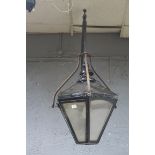 A COPPER AND BLACK PAINTED WALL MOUNTED LANTERN of octagonal tapering form with glazed panels