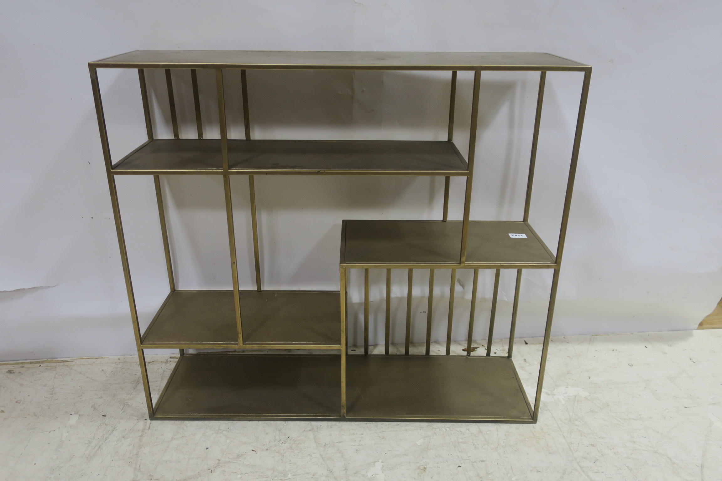 A METAL OPENWORK SHELF joined by tubular uprights 80cm (h) x 90cm (w) x 26cm (d)