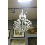 A CONTINENTAL CUT GLASS TWELVE BRANCH OPEN WORK CHANDELIER hung with faceted chains and pendent