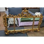 A CONTINENTAL GILT FRAME COMPARTMENTED OVER MANTLE MIRROR the foliate and flower head frame with