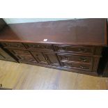 A CANADIAN STAINED WOOD LOW BOY of rectangular outline the shaped top above seven long drawers and