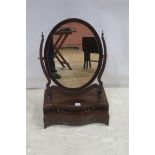 A GEORGIAN MAHOGANY CRUTCH FRAMED MIRROR the oval plate within a moulded frame raised on a