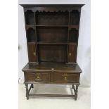 AN OAK WELSH DRESSER the outswept moulded cornice above open shelves and cupboards the base with