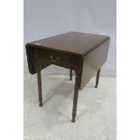 A GEORGIAN MAHOGANY DROP LEAF TABLE the rectangular hinged top above a frieze drawer on turned legs