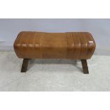 A STAINED WOOD AND HIDE UPHOLSTERED GYM HORSE STOOL the rectangular upholstered seat raised on
