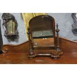 A 19TH CENTURY MAHOGANY CRUTCH FRAME MIRROR with rectangular arched plate raised on ring turn
