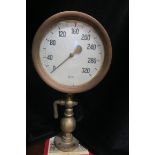 A 20TH CENTURY BRASS INDUSTRIAL OR MARINE PRESSURE GAUGE the 9½" enamel dial calibrated up to 320