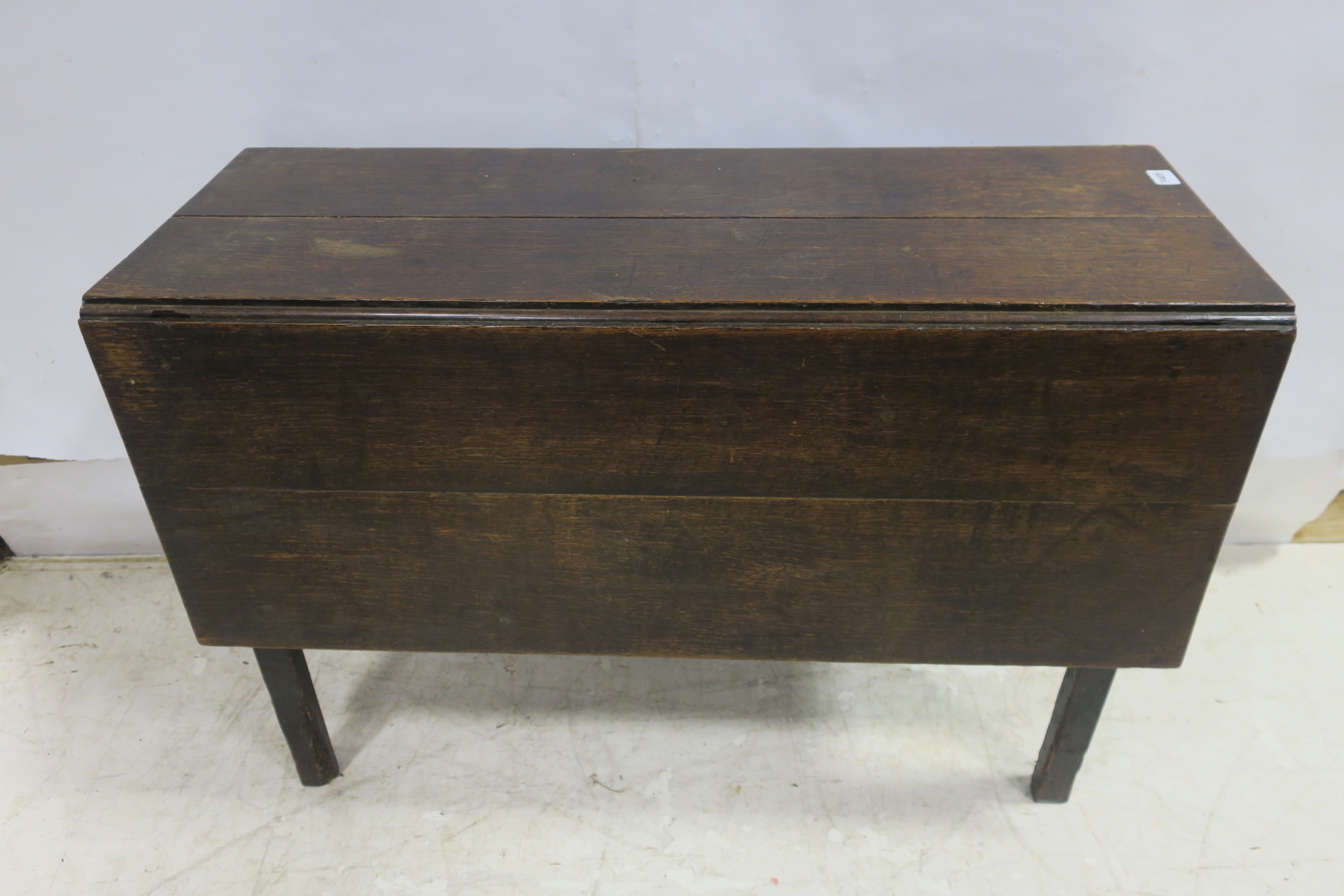 A GEORGIAN OAK DROP LEAF TABLE the rectangular hinged top raised on square moulded legs 71cm (h) x