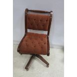A MAHOGANY UPHOLSTERED SWIVEL OFFICE CHAIR with deep buttoned upholstered back and seat on