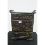 A CHINESE LACQUERED TABLE CABINET with frieze drawers and cupboard on bracket feet 43cm (h) x 33cm