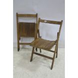 A PAIR OF BEECHWOOD FOLDING CHAIRS each with a shaped slatted seat on moulded legs