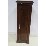 A 19TH CENTURY MAHOGANY CUPBOARD the square stepped top above a rectangular arch panelled door