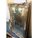 A CONTINENTAL SILVER AND GILT FRAMED MIRROR the rectangular bevelled glass plate within a lattice