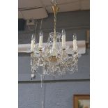 A CONTINENTAL CUT GLASS AND GILT BRASS EIGHT BRANCH CHANDELIER hung with faceted chains and drops