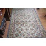AN ORIENTAL WOOL RUG the beige and light green fleck ground with central floral panel within a