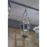 A BRASS AND GLAZED HALL LANTERN of octagonal tapering form suspended on three reeded link chains