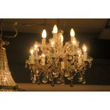 A CONTINENTAL CUT GLASS TWELVE BRANCH CHANDELIER in two registers hung with faceted chains and