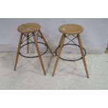A SET OF FOUR HARDWOOD AND BRASS IDUSTRIAL STOOLS each with a circular dish seat on splayed legs