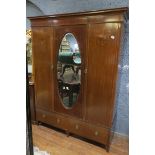 A 19TH CENTURY MAHOGANY AND SATINWOOD INLAID THREE DOOR WARDROBE the moulded cornice above an oval