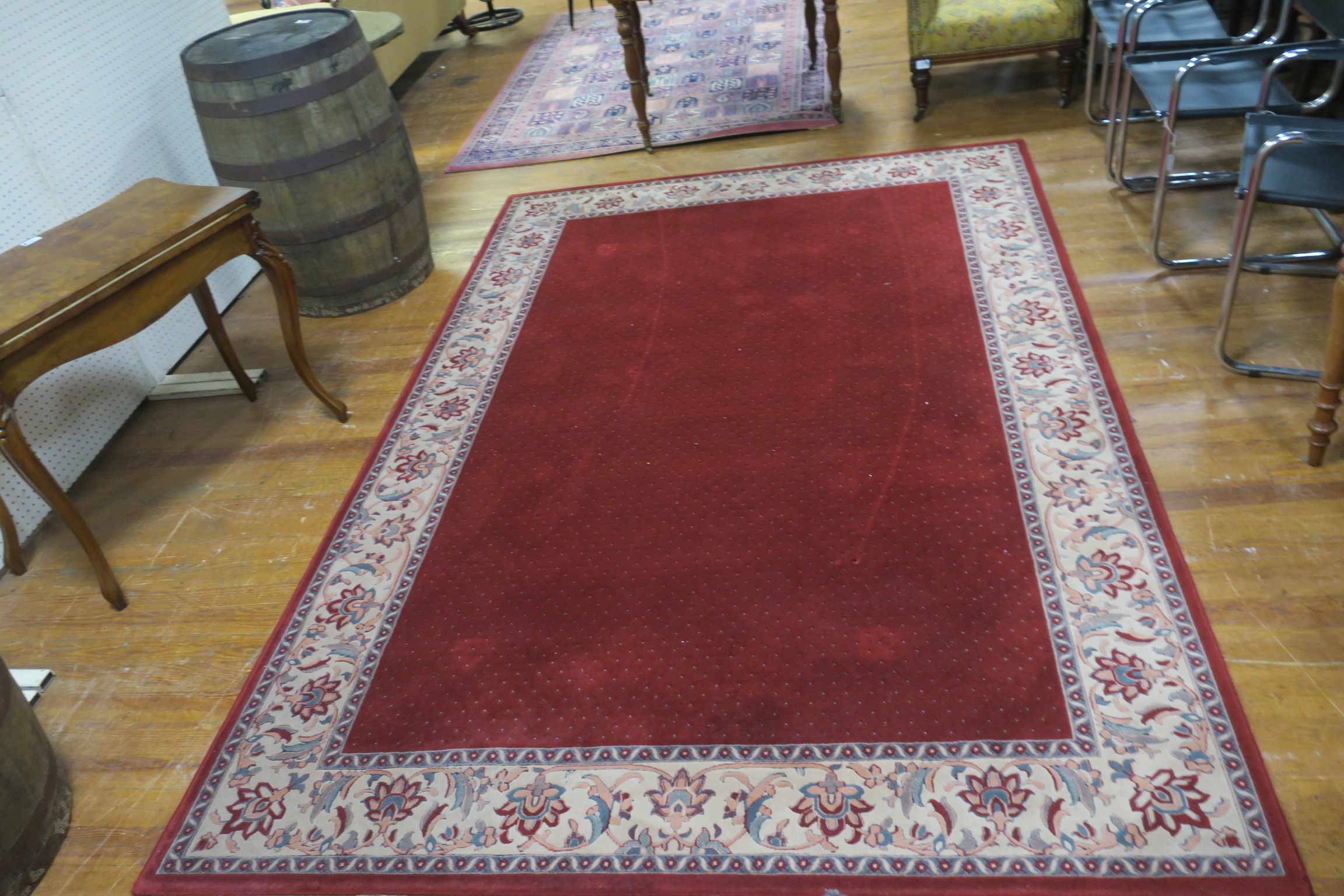 A WOOL RUG the wine and beige ground with stylized foliate and flower head border 300cm x 200cm