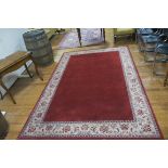 A WOOL RUG the wine and beige ground with stylized foliate and flower head border 300cm x 200cm