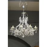 A CONTINENTAL CUT GLASS EIGHT BRANCH OPEN WORK CHANDELIER hung with faceted chains and pendent