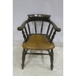 A STAINED WOOD BOWED SMOKER'S CHAIR the curved back with baluster splats and hide upholstered seat