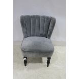 A RETRO GREY VELVET UPHOLSTERED WING CHAIR with panel back and seat on baluster legs